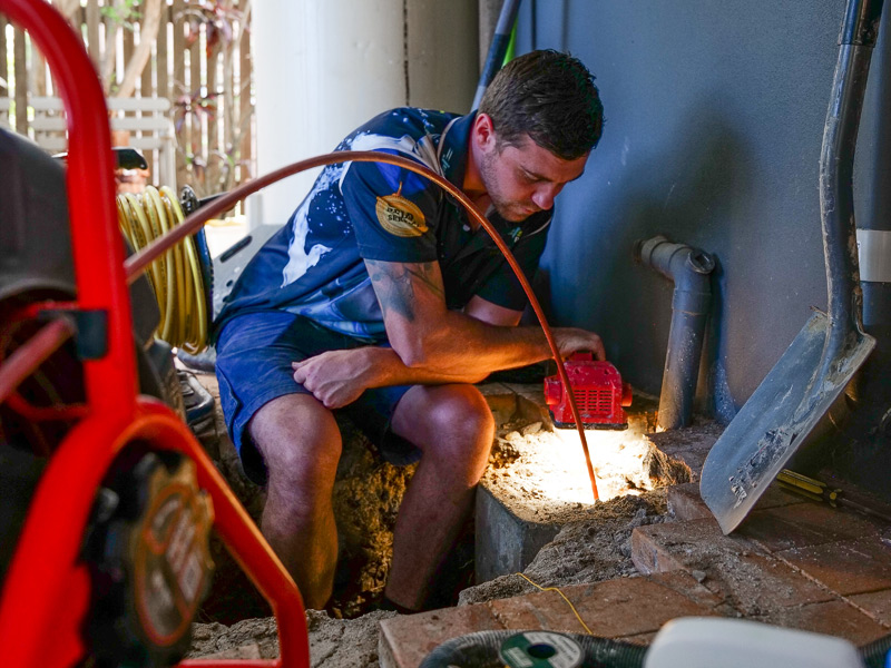 Plumber clearing a blocked drain